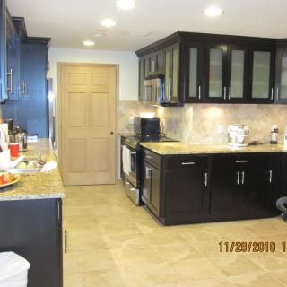 A modern kitchen with dark cabinets and tiled flooring.