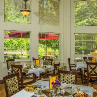A cozy restaurant dining area with large windows offering a scenic view.