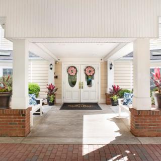 Charming building entrance with decorative doors and vibrant plants.