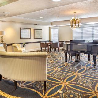 A spacious living room with elegant furniture and a grand piano.