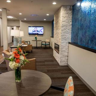 A modern lobby with cozy seating, a fireplace, and stylish decor.