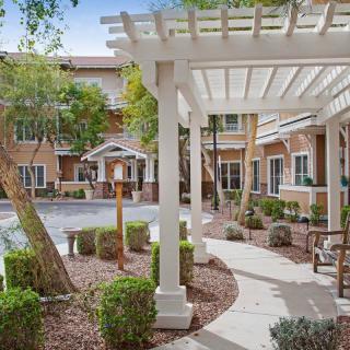 A peaceful courtyard with a pergola and landscaped gardens.