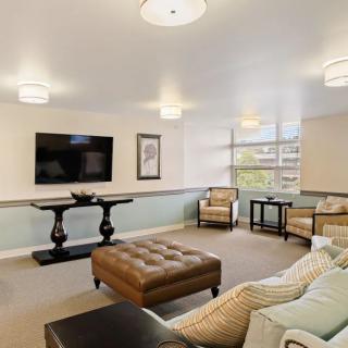 A modern living room with comfortable seating, a wall-mounted television, and stylish lighting.
