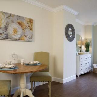 A cozy dining nook with a wooden table, upholstered chairs, and decorative wall art.