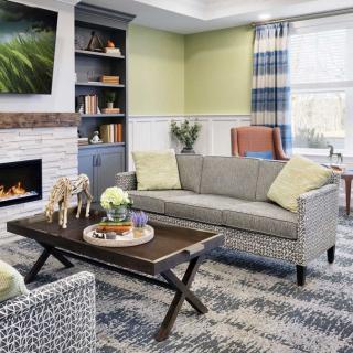 A modern living room with a cozy fireplace, stylish furniture, and decorative accents.
