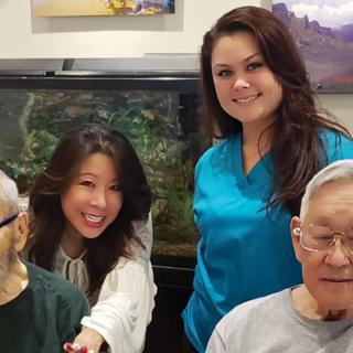 Group photo of healthcare workers and seniors smiling together.