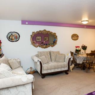 A cozy living room with classic decor, featuring two sofas and a dining area.