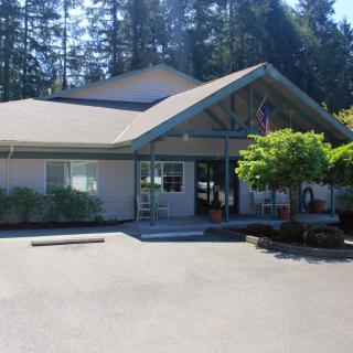 A building with an entrance surrounded by trees on a sunny day.