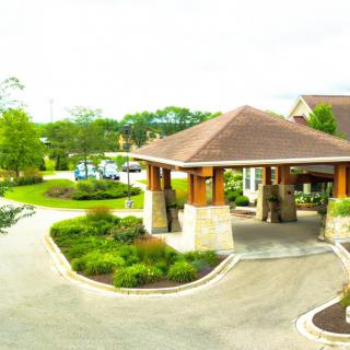 A scenic view of a building entrance surrounded by landscaped greenery.