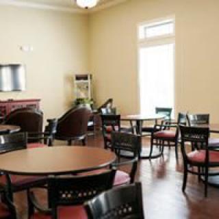 An empty dining area with several round tables and chairs.