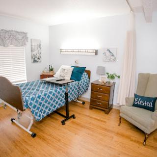 A cozy and well-decorated bedroom featuring a hospital bed, stylish furniture, and warm lighting.
