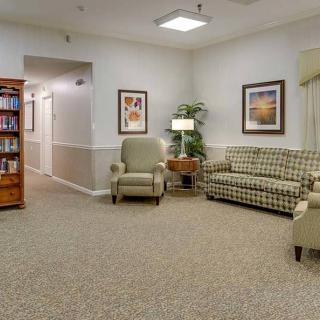 A comfortable waiting room with chairs, a sofa, and a bookshelf.