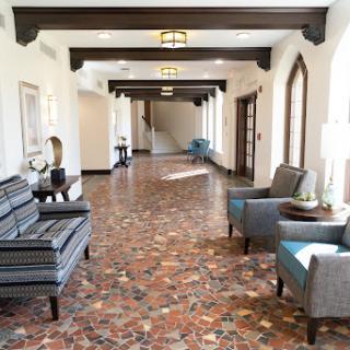 A spacious and elegantly designed hallway featuring comfortable seating and decorative lighting.