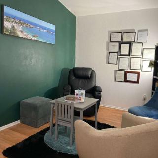 A cozy office space with comfortable seating and certificates displayed on the wall.
