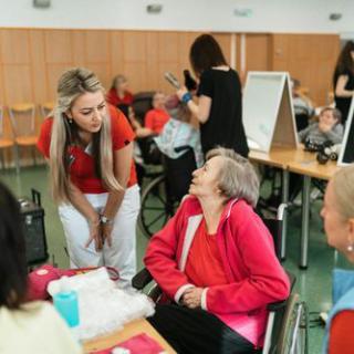A caregiver engages in a heartfelt conversation with an elderly resident during a community activity.