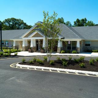 A modern building with a well-landscaped entrance and surrounding greenery.