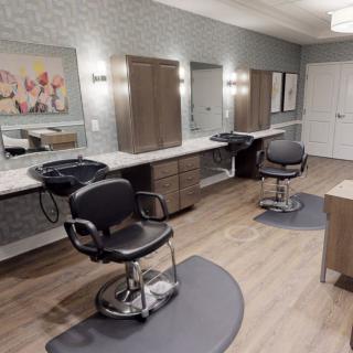An empty hair salon with chairs and mirrors.