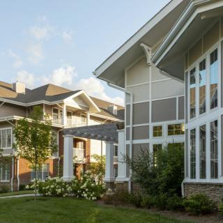 Modern residential building with large windows and landscaped surroundings.