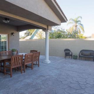 A spacious backyard patio with a dining set and additional seating.