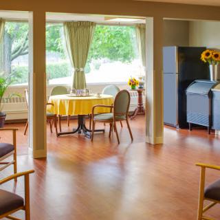 A bright and inviting dining area featuring a round table with chairs, surrounded by large windows that let in natural light.