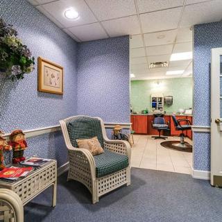 A cozy waiting area with wicker furniture leading into a salon room.