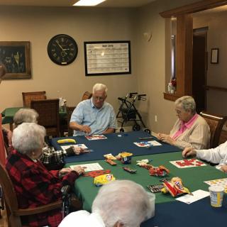 A group of seniors engaged in a card game at a community center.
