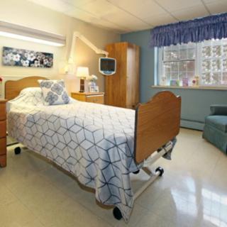 A clean and well-furnished hospital room with a single bed.