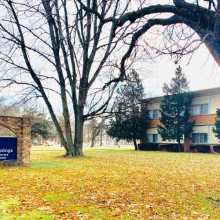 A campus building surrounded by trees in an autumn setting.
