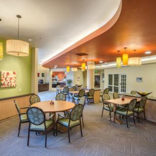 A modern and inviting dining area with tables, chairs, and warm lighting.