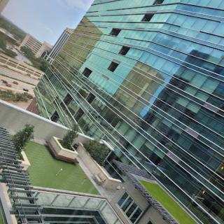 A view of a contemporary building with a glass exterior and landscaped outdoor area.