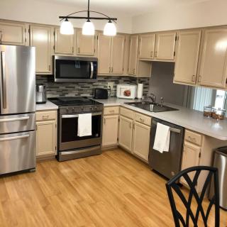 A modern kitchen with stainless steel appliances and wood flooring.