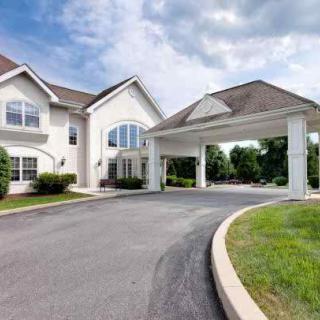 A large residential building with a covered entrance and driveway.