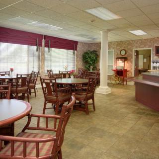 A restaurant dining area with neatly arranged tables and chairs near large windows.
