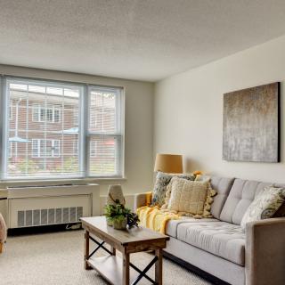 A cozy living room with a comfortable sofa, coffee table, and large window.