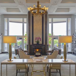 A luxurious lobby featuring elegant lighting, a central seating area, and large windows.