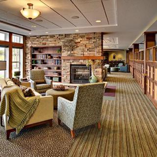 A cozy living room featuring comfortable seating, a stone fireplace, and bookshelves, perfect for relaxation.