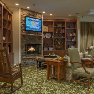 A cozy living room with a fireplace, bookshelves, and comfortable seating.