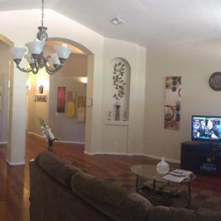A cozy living room with modern decor and a chandelier.