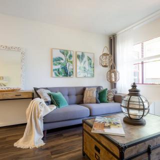 A cozy living room with a comfortable sofa, decorative pillows, and contemporary artwork.