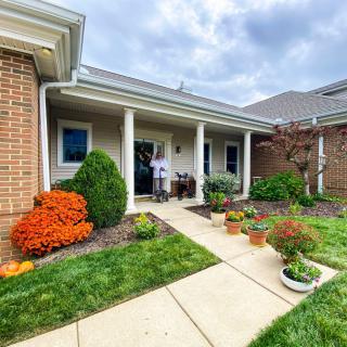 A charming house entrance with a well-maintained garden and potted plants lining the pathway.