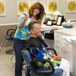 A stylist giving a haircut to a client in a modern salon.