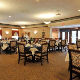 A formal dining room with neatly arranged tables and chairs.