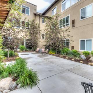 A well-maintained apartment courtyard with lush greenery and seating areas.