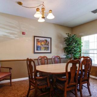 A cozy dining room with a round table, elegant chairs, and warm lighting.