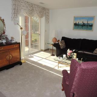 A cozy living room with a sofa, armchair, and elegant decor.