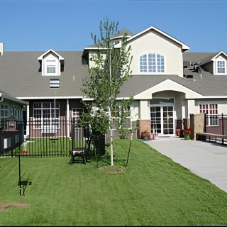 A suburban residential house with a well-maintained lawn and driveway.