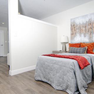 A modern bedroom with stylish decor and a cozy bed.