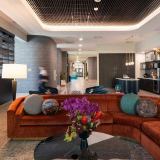 A modern and luxurious living room with a large orange sofa and stylish decor.
