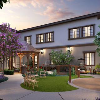 A beautiful house with a well-maintained garden and outdoor seating area during the evening.