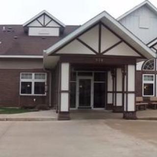 A residential building entrance with a gabled roof and brick facade.